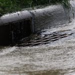 Storm drain with water running into it