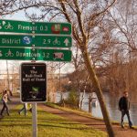 Burke-Gilman trail on a sunny day, with biking signs and passing pedestrians