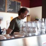A barista prepares a beverage for a customer.
