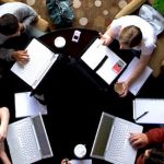 A group of people collaborate around a table.