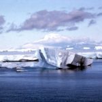An iceberg floats past an ice shelf in the North Atlantic.