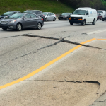 Cars pass by a section of buckled highway in Decatur, Ga., Monday, April 17, 2017.