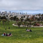 Dolores Park in San Francisco with social-distancing circles painted on the grass to help small family groups stay safely away from each other.