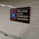The western end of the passageway at the Times Square–42nd Street / Port Authority subway complex in Midtown Manhattan, leading between the IND station at 8th Avenue and the rest of the station at Times Square. Pictured is the sign informing passengers that the ramps and passageway are not ADA accessible.