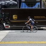 UPS truck stopped beside a biker