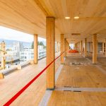 The view from the inside of a tall wood building in construction.