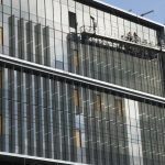 The side of the Life Sciences Building, with people working on the paneling of the windows.