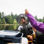 Associate professor Rebecca Neumann places dog food, commonly used as bait, in a crayfish trap