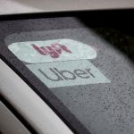 Uber and Lyft stickers on a windshield.