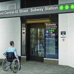 Man in wheelchair approaching elevator at Grand Central subway station in New York City