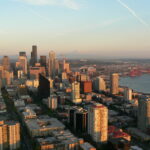 Aerial image of the Seattle waterfront at dusk on a sunny day. Taken from the Space Needle.